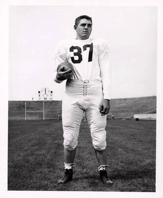 Freshman football player, Darrell Surber (#37), standing on the University of Idaho football field with a ball.