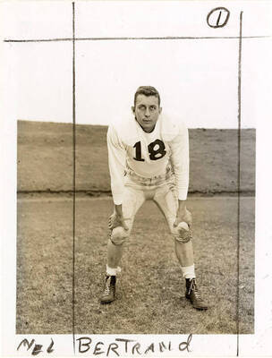 Mel Bertrand (#18), center for the University of Idaho football team, standing with his hands on his knees.
