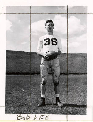 Bob Lee (#36), fullback for the University of Idaho football team, standing and holding a ball on the football field.