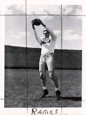 John Ramos (#28), end for the University of Idaho football team, catching a football on the field.
