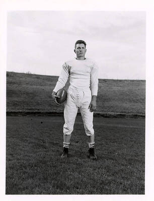 Halfback for the University of Idaho football team, Ted Frostenson standing on the football field.