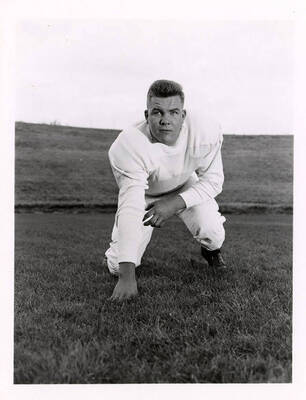 Bob Noble, a tackle player for the University of Idaho, kneeling on the field.