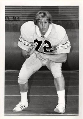 A football player wearing the number 72 looks at the camera in awe for an action portrait shot.