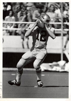 #12 for the University of Idaho football team prepares to throw the ball during a football game.