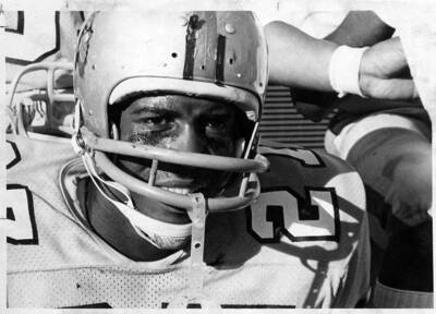 A close up headshot of a sweaty Vandal football player on the sidelines during a football game.