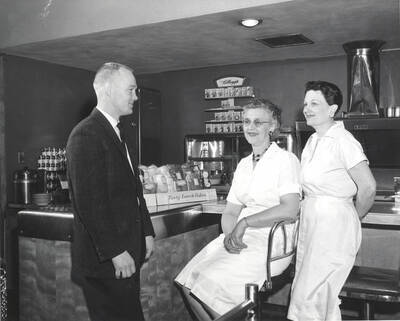 Student Union Building employees Dean L. Vettrus (food service manager), Marie Bippes (assistant foods manager) and Mary Humphreys (cafeteria manager) pose for a photo in the SUB cafeteria.
