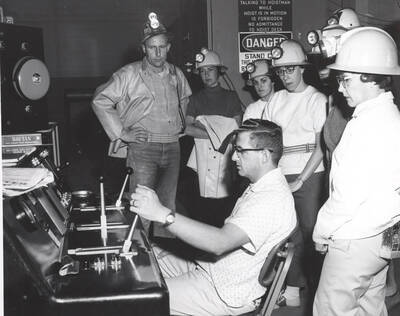 Junior High and Senior High school teachers watch a hoistman at work in the Lucky Friday Mine at Mullan.