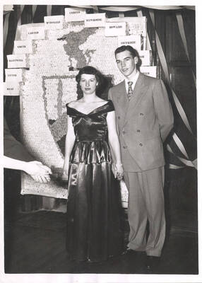 An unidentified Beta Theta Pi member poses with his date at the organization's formal dance.