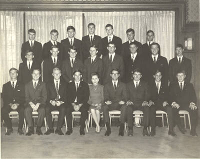 Members of the Beta Theta Pi fraternity pose for a group photo with their House Mother Mrs. Cummins in their house.
