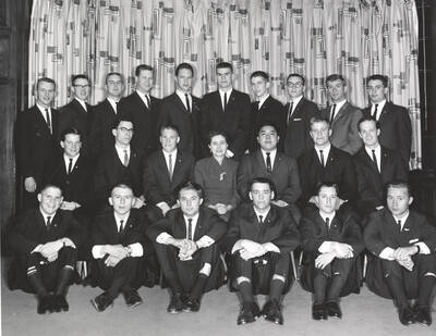 Members of the Beta Theta Pi fraternity pose for a group photo with their House Mother Mrs. Cummins in their house.