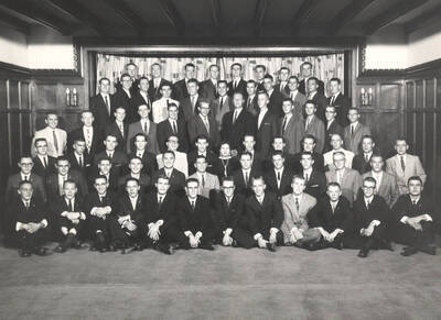 Members of the Beta Theta Pi fraternity pose for a group photo with their House Mother Mrs. Cummins in their house.