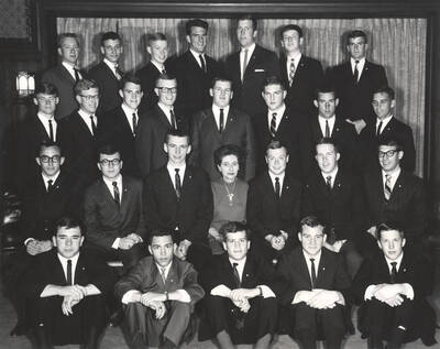 Members of the Beta Theta Pi fraternity pose for a group photo with their House Mother Mrs. Cummins in their house.