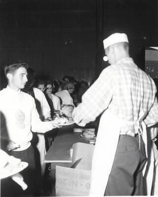 Students lined up and receiving food at the all campus barbecue located in the old arboretum.
