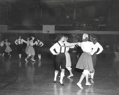 Groups of women dance in pinwheel formations during the folk dance festival.