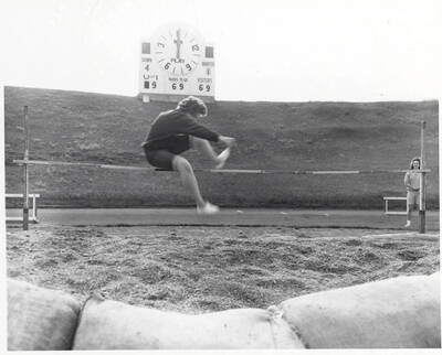 A woman competes in the high jump at a track meet.