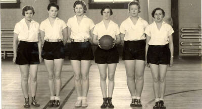 Women's Recreation Association freshman basketball team posing for a photo. Individuals identified as listed: Mary Eileen Kennedy, Ruth W. Lacy, Jessie Ruth Evans, Gertrude Lorraine Olesen, Alma Sophia Almquist, Geraldine Rosalie Langer.