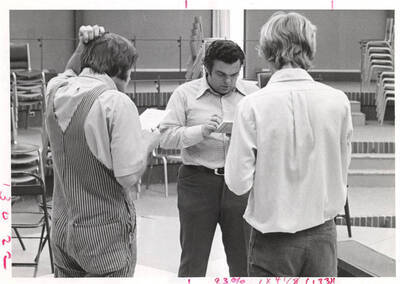 Professor Forrest Sears [Center] and two theater students read lines in a Summer Theatre rehearsal in the Kiva. Summer Theatre was staged in the KIVA from 1969 to 1973.