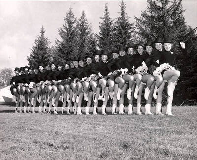 Vandalettes pose for a group photograph in passe in a line formation while wearing their uniforms.