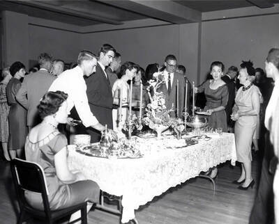 Faculty members get drinks from a punch bowl and talk during the faculty reception.