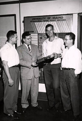 Leon Greene, intramural director, presents a plaque to Bruce Colwell and Dave Schmitt of Wilis Sweet Hall. Bill Last, on left, looks on.