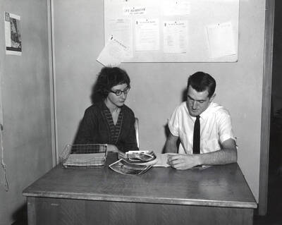 Linda Lamb Parkinson and Warren Dale Reynolds, co-editors of the Gem of the Mountains yearbook, look over photographs.