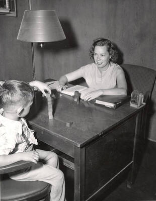 Mabel Merrel tests a child's intelligence using the Stanford-Binet test during the Summer Child Guidance Clinic.
