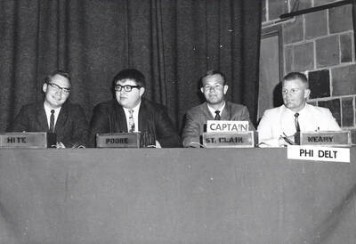 Men from Phi Delta Theta sit at a table after winning the All-Campus College Bowl competition. Individuals identified from left to right: Hite, Poore, St. Clair (captain), and Neary