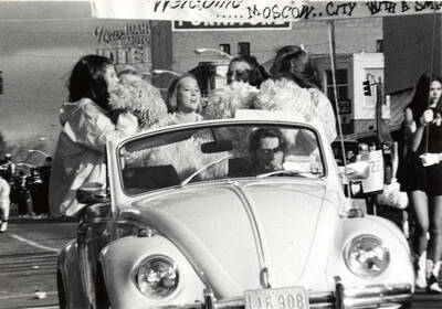 Pom-Pom Girls sit in the back of a Volkswagen Beetle during the Homecoming parade.