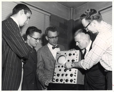 Robert James Twiggs (Alcoa Metallurgy Scholarship winner), Donald Jackson Beck (Hecla-Bunker Hill Scholarship winner), Everett Minnich Baily (Vaughen Henry Estrick winner), and James Lowell Gunderson (Western Electronics Manufacturers Assn. Scholarship winner) look over a Type 513D Cathode-Ray Oscilloscope.