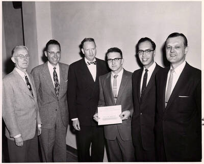 University of Idaho student Allen Stubberud shows his $500 scholarship from General Electric Company. Individuals identified from left to right: Professor J. Hugo Johnson, J.B. Holmes, Professor H.E. Hattrup, Stubberud, Glen W. Wimer, and Dean Allen S. Janssen.