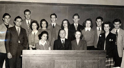 The Debate team poses for a group portrait in a classroom.