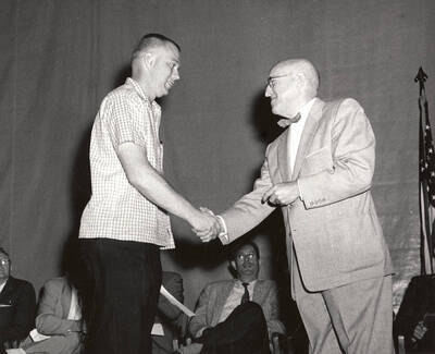 University of Idaho student Carl C. Hendricks receives the Phi Delta Kappa award from President Donald R. Theophilus.