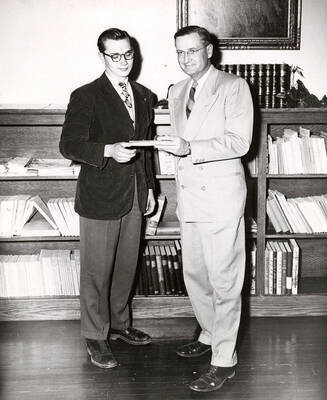 University of Idaho law student John Bengston receives a check for $300 from President Jesse E. Buchanan for his 6th place prize in a national essay contest.