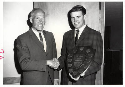 University of Idaho student Donald E. Schumacher receives the Phi Epsilon Kappa Outstanding Senior Award from Eric Kirkland.