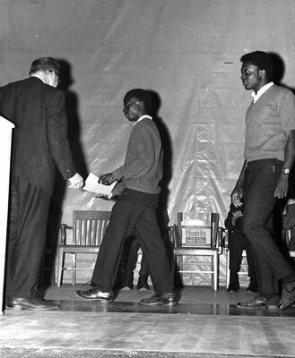 President Ernest W. Hartung presents certificates to Faustinus Kayiwa of Uganda and Alfred Susu of Nigeria for completion of their bachelor's degrees at the University of Idaho.