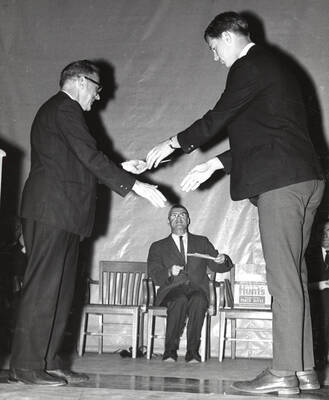President Ernest W. Hartung congratulates University of Idaho student Larry Rasmussen upon earning the annual Alpha Chi Rho award.
