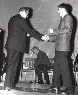President Ernest W. Hartung congratulates University of Idaho student Alfred Joseph Eiguren upon earning the Hamilton Watch award.