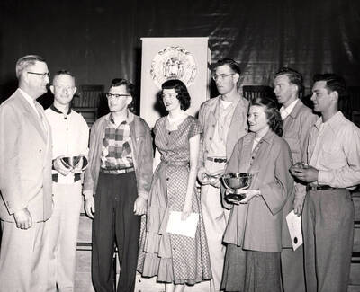 University of Idaho President Jesse E. Buchanan meets seven seniors who received special awards at commencement exercises. Individuals identified as listed. Left to right: Frank Burford, Calvin Burns, Sheila Janssen, John Thomas, Erlene Clyde, Graham McMullin, Richard Johnston