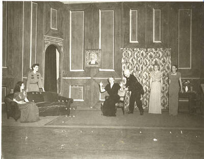 Students from l-r: Shirley Brandt as Joanna Trout, Patricia Barnes as Alice Dearth, Margaret Payne as Mrs. Coade, John Rowe as Lob, Dorothy Greaves as Lady Caroline, and Polly Harris as Mabel Purdie. The living-room scene of 'Dear Brutus' by Idaho drama students. An ASUI production directed by Jean Collette.