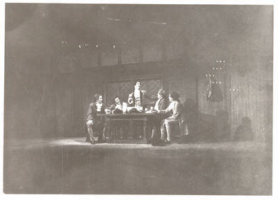 Performers from l-r: Fred Sugfriedt as Aminadale, Oscar Finkelnburg as Tom Twist, Dennis Savage as Tony Lumpkin, Denton Darrow as Jack Slang, Mark Pederson as Roger. Tony Lumpkin stands to talk at the table in Idaho drama's production of 'She Stoops to Conquer.' An ASUI production directed by Jean Collette in the University Auditorium.
