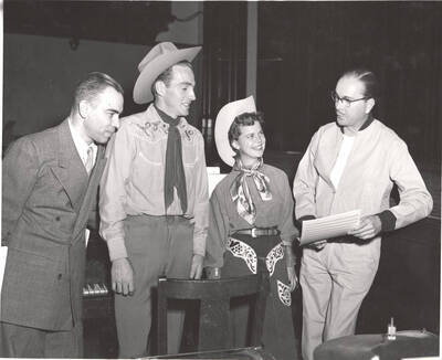 Performers from l-r: Ted Sherman, unidentified performer, Bonese Collins, Hall Macklin (musical score). Macklin explains the upcoming scene of the play, 'Sing, Senator, Sing' to performers in Idaho's drama department.An ASUI production written by Geoffrey Coope, Theodore Sherman, & music Hall Macklin (all UI teaching faculty), directed by Jean Collette in the University Auditorium.