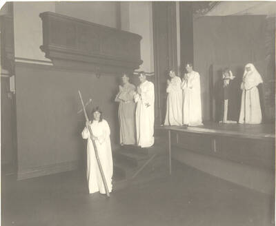 Soulen, as Everyman, leads a group of holy-people down the stairs with a cross in-hand in Idaho drama's production of the play, 'Everyman.' Presented by the English Club, directed by Henrietta E. Moore