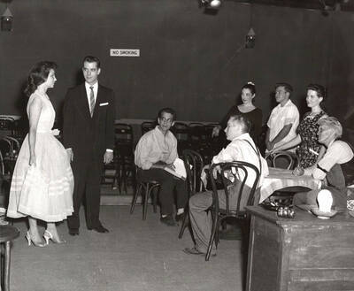 Unidentified actors performing a group scene during a drama production of 'You Can't Take It With You'. Summer Theatre in the Field House directed by directed by Agnes Risetter.