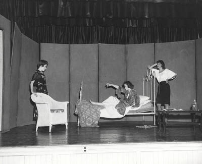 Three cast members perform a bedroom scene during a drama production of 'Mooney's Kid Don't Cry'. Cast includes Buzz McCabe and Carole Hurley. Advanced Play production Class in the U-Hut Studio Theater directed by Bonnie Scott.