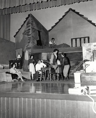 Cast members perform a group scene together during a drama production of 'Diary of Anne Frank'. ASUI production directed by Jean Collette. Cast includes Earl Pederson, Donna Morgan, Vicki Seibert, William Johnston, Gary Whitmore, Sally Willbanks, Diane Fawson, Angie Arrien, Lorenzo Nelson, and Sam Collet.