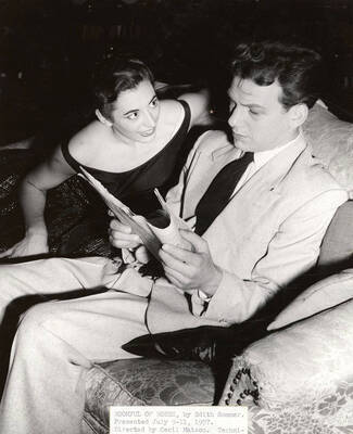 A woman looking at a man reading. 'Roomful of Roses' directed by Cecil Matson for Summer Theatre in the Field House.