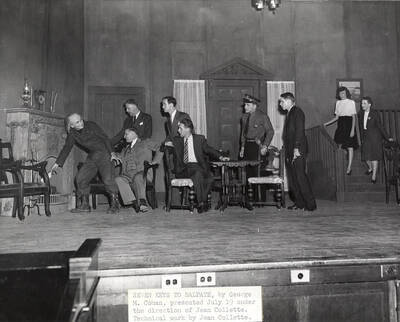 ASUI production of 'Seven Keys to Baldpate' by the University Players in the University Auditorium. Directed and designed by Jean Collette. One man putting something in the fireplace and a group staring at him.