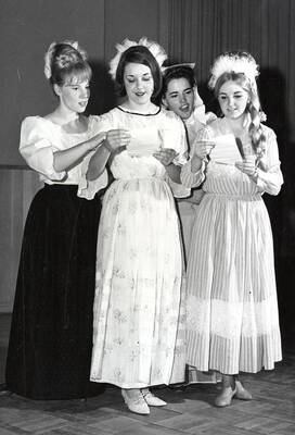 L-r: Roberta Timm, Twyla Brunson, Tecla Guerra and Janice Johnson standing in a group looking at pieces of paper.