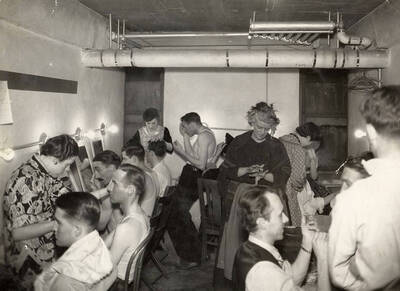 Men sitting in the make-up room during the drama production of "Night Over Taos." Cast: Eldred Stephenson as Pablo Montoya, Bill Cherrington and Don Tracy as Frederico and Felipe, Malcolm Renfrew as Martinex, Murva James as Diana, Marian Swanson as Dona Josefa and Erma Lewis as Veri. ASUI production directed by Fred Blanchard in the  University Auditorium.