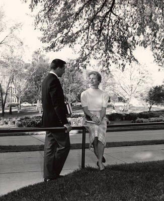 Francis Bodick sits on a fence talking to Bruce Summers.